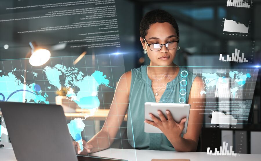 Mulher analisando dados em tablet e computador