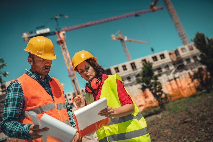 Profissionais analisando planos em obra de construção